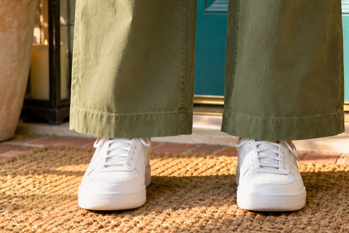 Olive trousers with the hem taken up above white sneakers