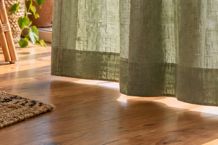 Linen curtain hem sitting evenly above a wooden floor
